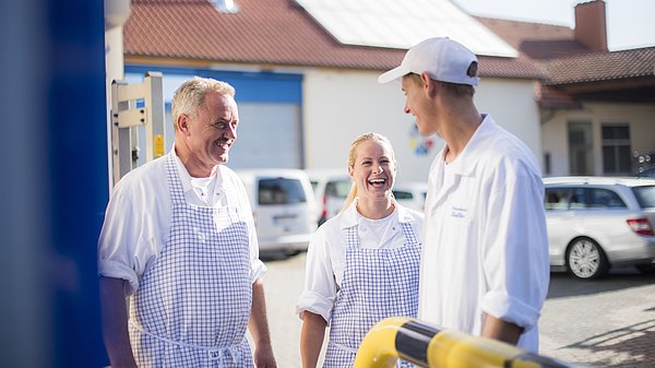 Drei Metzger lachen miteinander 